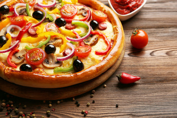 Delicious pizza with vegetables, on wooden table