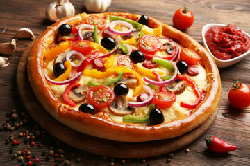 Delicious pizza with vegetables, on wooden table, close-up