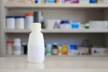 Blank white label of medicine bottle with blur shelves of drug i