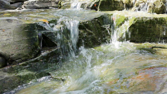 Mountain stream between stones. Little rapids.