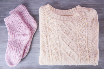 Hand made warm clothes on wooden background