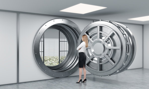 young lady standing in front of a big unlocked round metal safe
