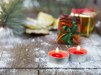 Candles and gifts in snow