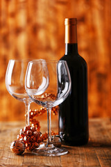 Red wine and Christmas ornaments on wooden table on wooden background