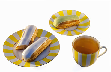 Delicious eclairs and a cup of tea on a white background