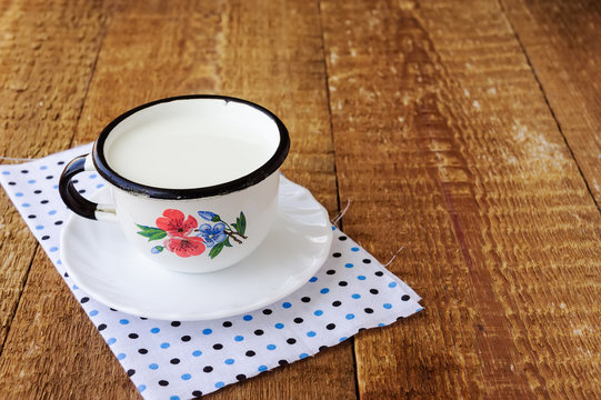 Mug of milk on wooden table