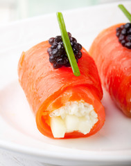 Smoked salmon rolls with cream cheese, black caviar