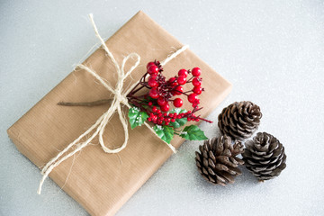 Christmas gift  and pine cones on a silver background