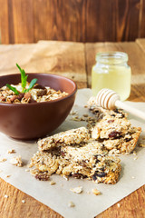Homemade granola bars with dried fruits and nuts, a jar of honey