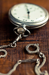 orologio da tasca antico con catenella; messa a fuoco su carica a molla, fotografia con effetto vintage 