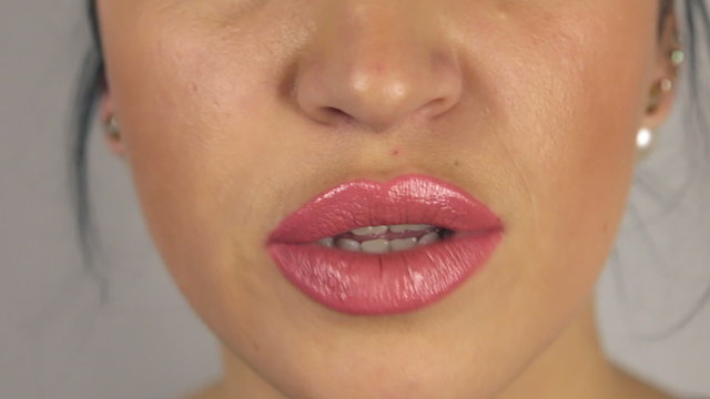 Brunette girl puts finger to her mouth, urging silent