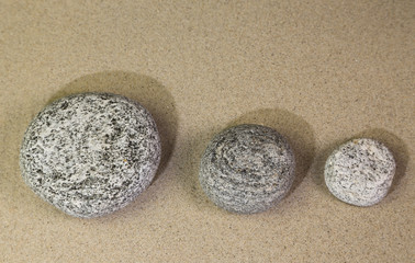 drei runde Steine im Sand