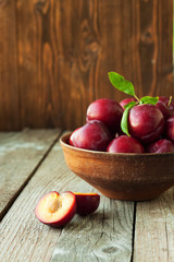 Plums on rustic wooden background