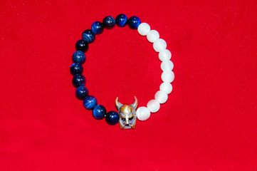 Viking figure blue and white bead men bracelet isolated on red background