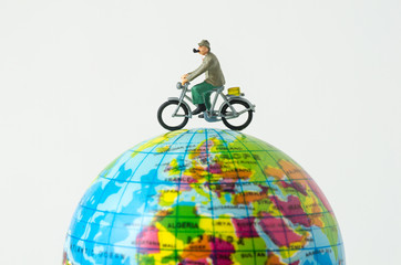 miniature people riding bicycle around the globe © kwanchaift