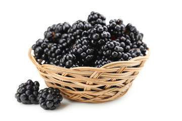 Beautiful ripe blackberry in basket on white background
