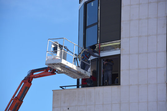 obreros instalando las ventanas de un edificio