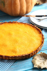 Tasty pumpkin pie on a blue wooden table
