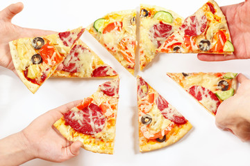 Child and adult hands snapping up pieces of a tasty pizza