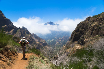 The traveler goes on a track highly in the mountains of Madeira