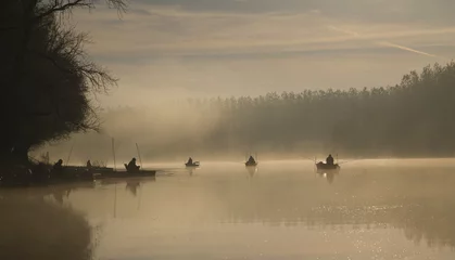 Fototapeten People fishing in the early morning on the lake © Geza Farkas