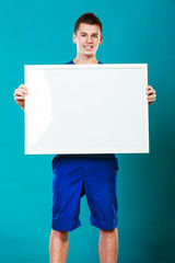 man holding blank presentation board on blue