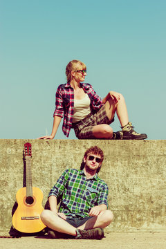 Young man playing guitar to his girlfriend by seaside