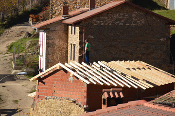 obrero trabajando sobre un tejado © uzkiland