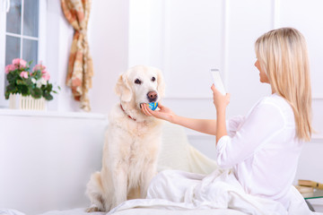 Caring woman lying on bed with her dog 