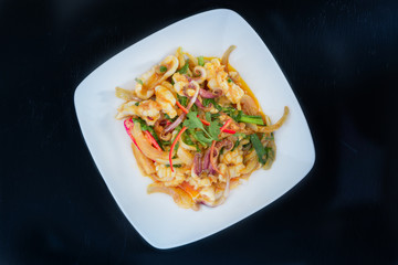 Stir Fried squid with salted egg york on black background