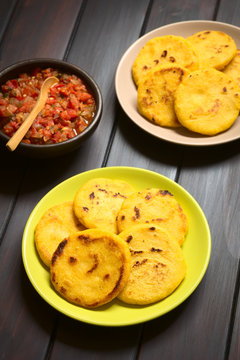 Colombian Arepa corn meal patties with hogao sauce (tomato and onion cooked) on the side (Selective Focus, Focus on the first arepas)