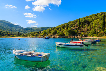 Fototapeta na wymiar Greek fishing boats on turquoise sea water in beautiful bay, Kefalonia island, Greece
