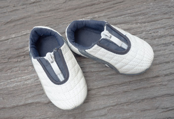 baby shoes standing on stones