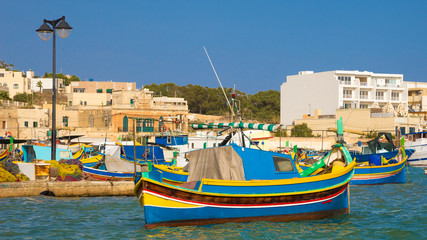 Fototapeta na wymiar Colorful Luzzu fishing boats in Marsaxlokk harbor, Malta