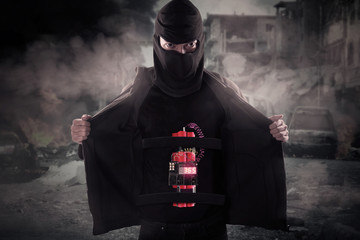 Portrait of man showing time bomb on his body against damaged city