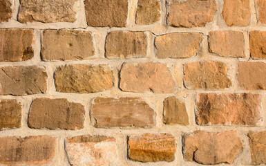 Sandstone brick wall bathed in afternoon sun
