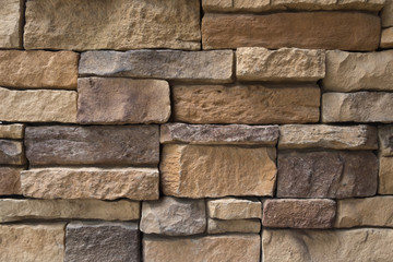 Brown stone brick wall in the sunny day / The brown stone brick in the zigzag form of building construction and decoration