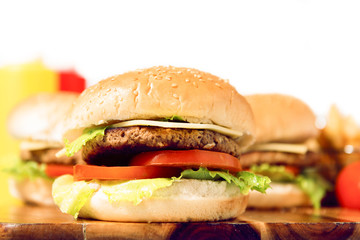 Hamburgers with cheese, potato chips and ingredients on a white background