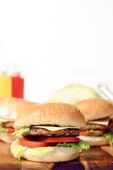 Hamburgers with cheese, potato chips and ingredients on a white background