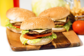 Hamburgers with cheese, potato chips and ingredients on a white background