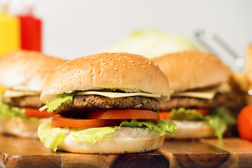 Hamburgers with cheese, potato chips and ingredients on a white background
