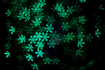 Green  snowflake bokeh in the dark.