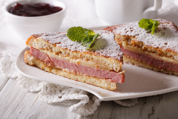 Sandwich of Monte Cristo close-up on a plate and berry jam.

