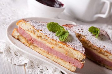 Tasty sandwich of Monte Cristo with ham and cheese close-up 
