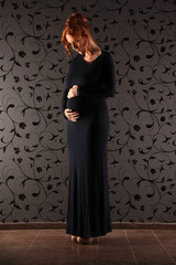 Ein schwangere Frau im schwarzen Kleid