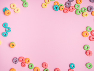 Colorful cereal  on a pink  background