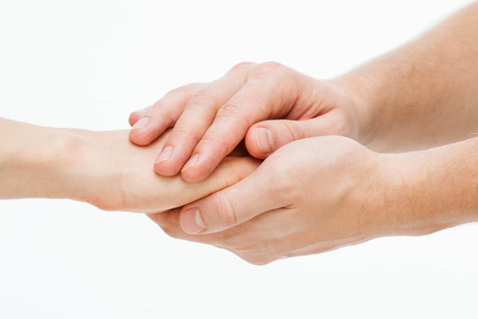Man's hands gently holding woman's hands