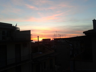 Naklejka premium Tramonto dietro le case