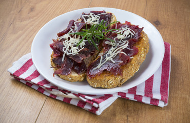 Plato de tostas de cecina y queso de cabra