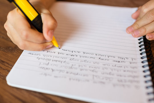 Girl writing by hand on notepad